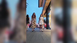 白いドレスを着た若い女性が親友とショッピングをしながら映画を見ています ipcam